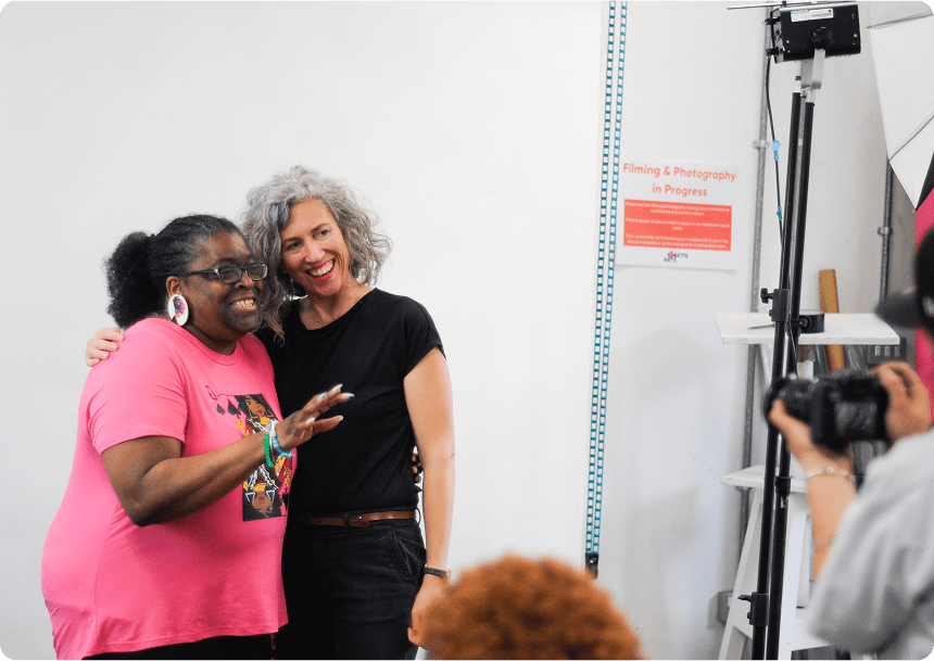 Two People smiling with their arms around one another posing for a picture